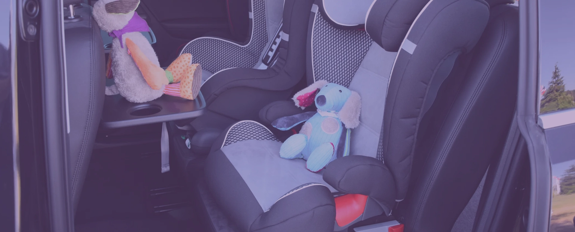Two child seats in the car with toys Two child seats in the car with toys